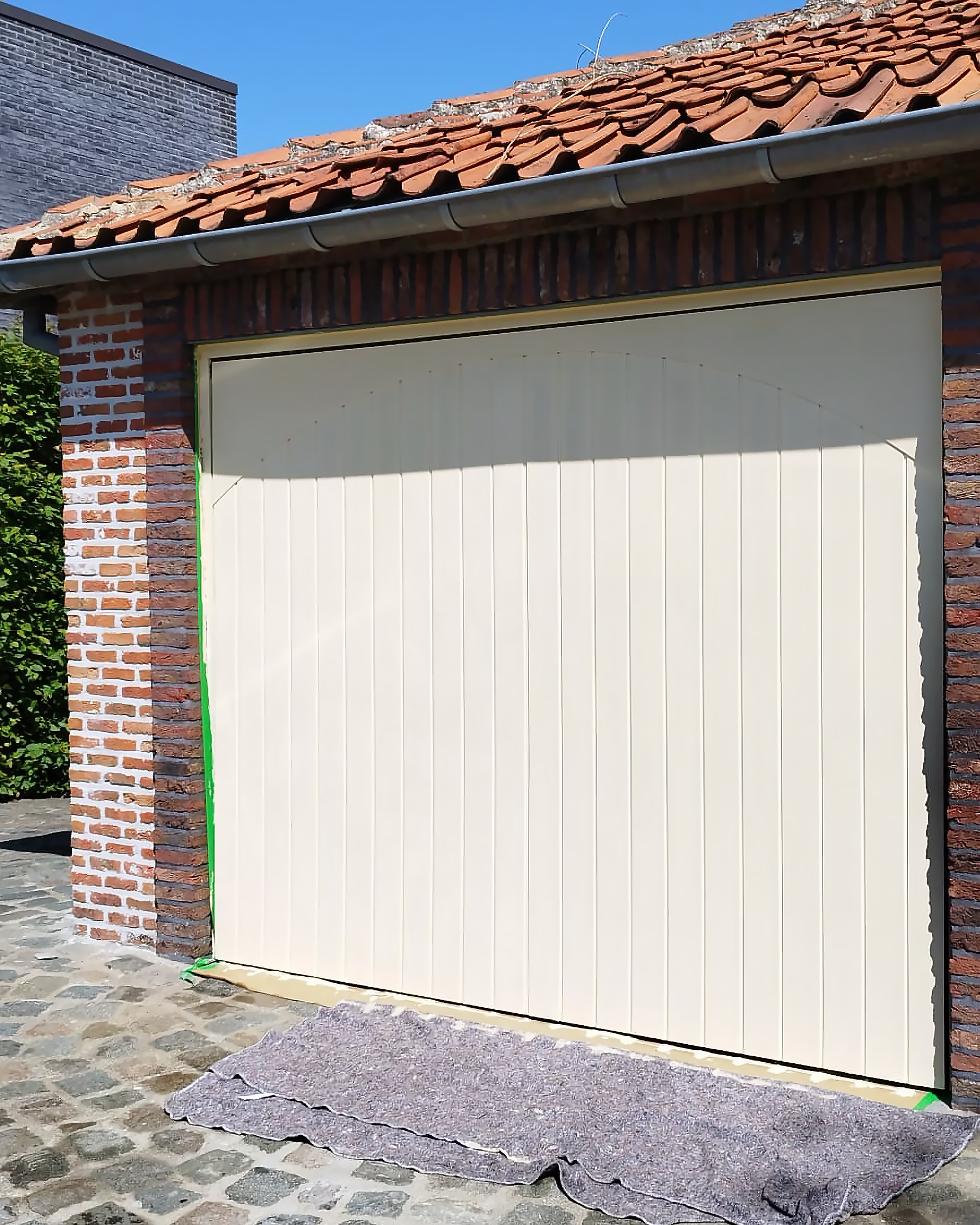 Professioneel geschilderde houten garagepoort met duurzame afwerking.