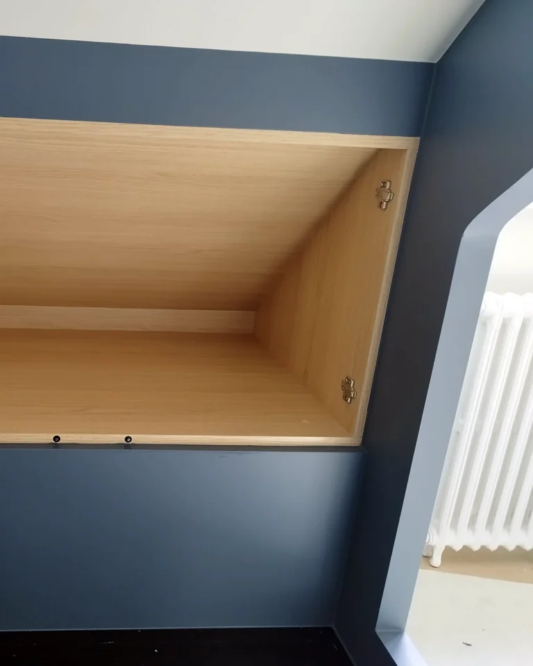 Strak afgewerkte maatwerkkasten met professioneel lakwerk in een zolderkamer.
