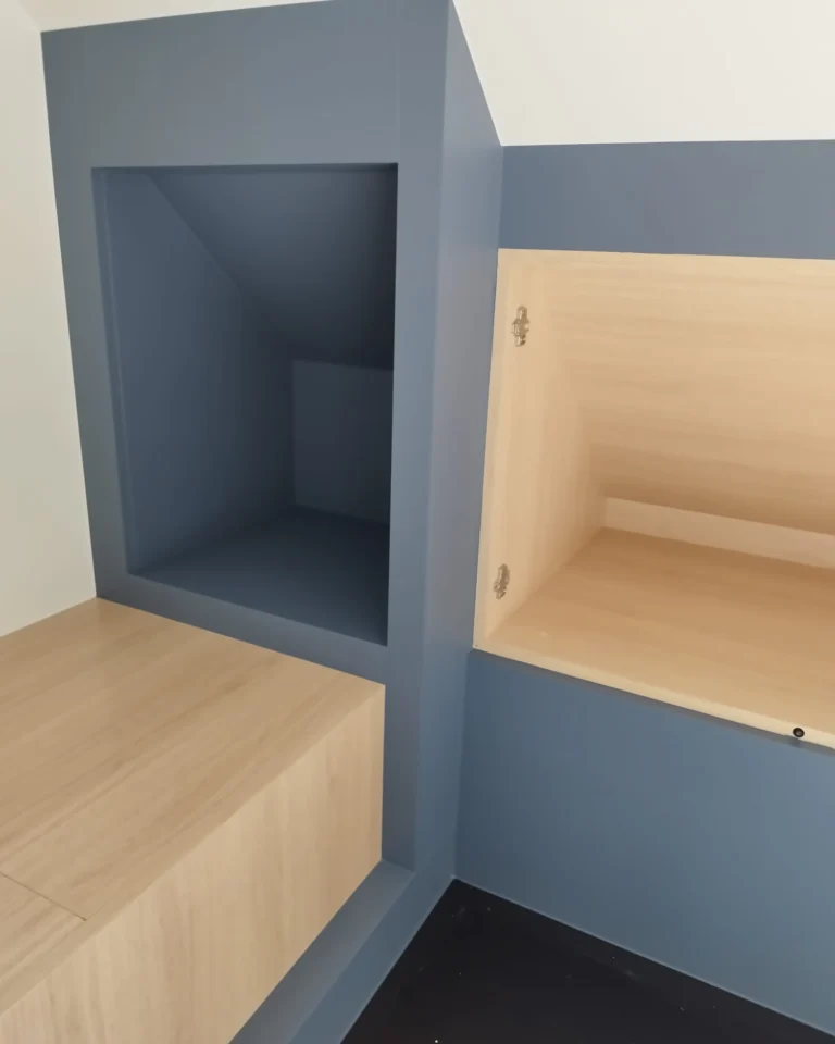 Strak afgewerkte maatwerkkasten met professioneel lakwerk in een zolderkamer.