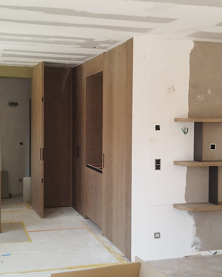Schilderwerken en wandafwerking rond maatwerk in een modern interieur.