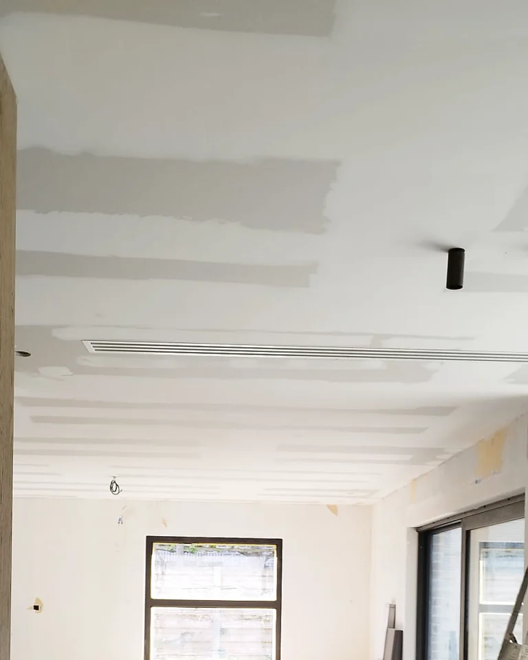 Voorbereiding en schilderafwerking van een plafond met ingebouwde verlichting.