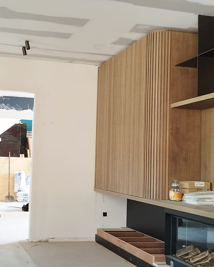 Nauwkeurige schilderafwerking van muren en plafond rondom houten maatwerk.