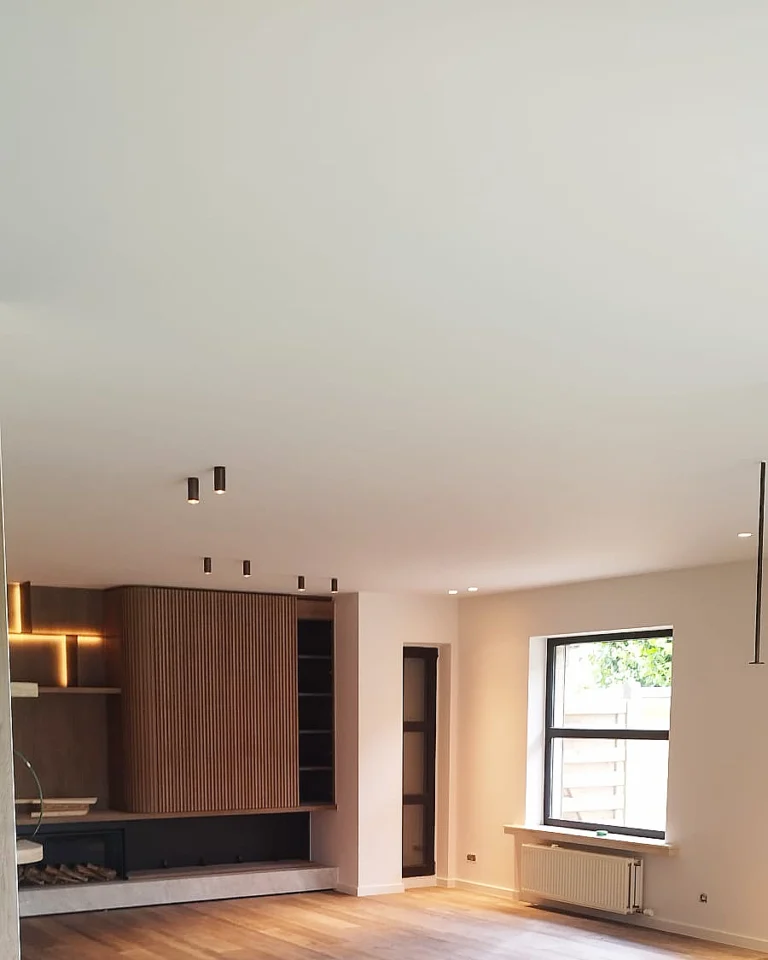 Professioneel afgewerkte muren en plafond in een moderne leefruimte met maatwerk.
