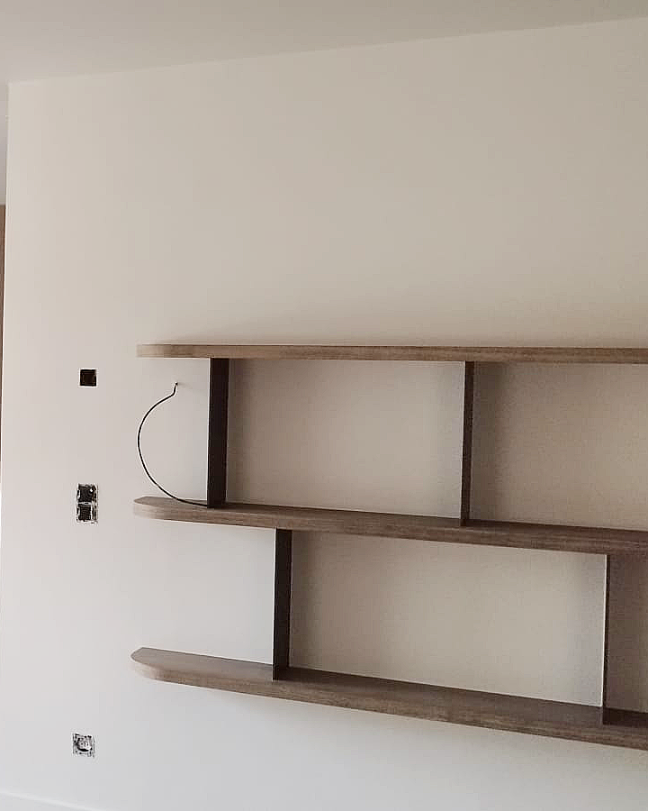 Strakke schilderafwerking van een binnenwand rondom houten wandplanken en maatwerk.