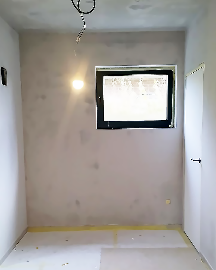 Strak geplamuurde wand klaar voor de afwerking.